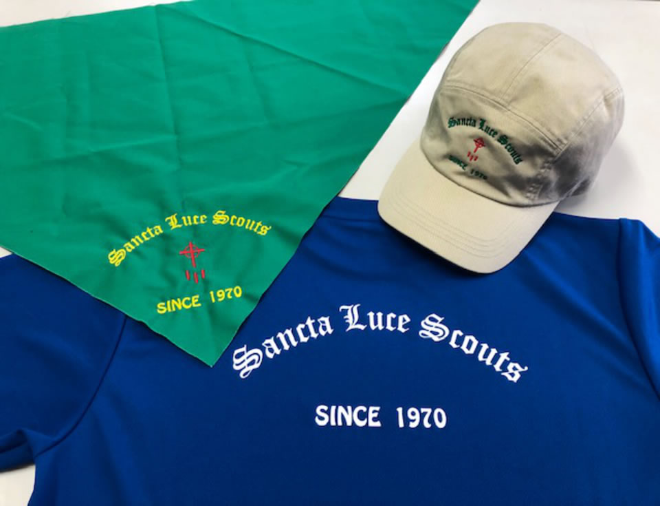 創立50周年の記念品ブルーのTシャツとロゴが入ったグリーンのスカーフと薄い肌色のキャップ